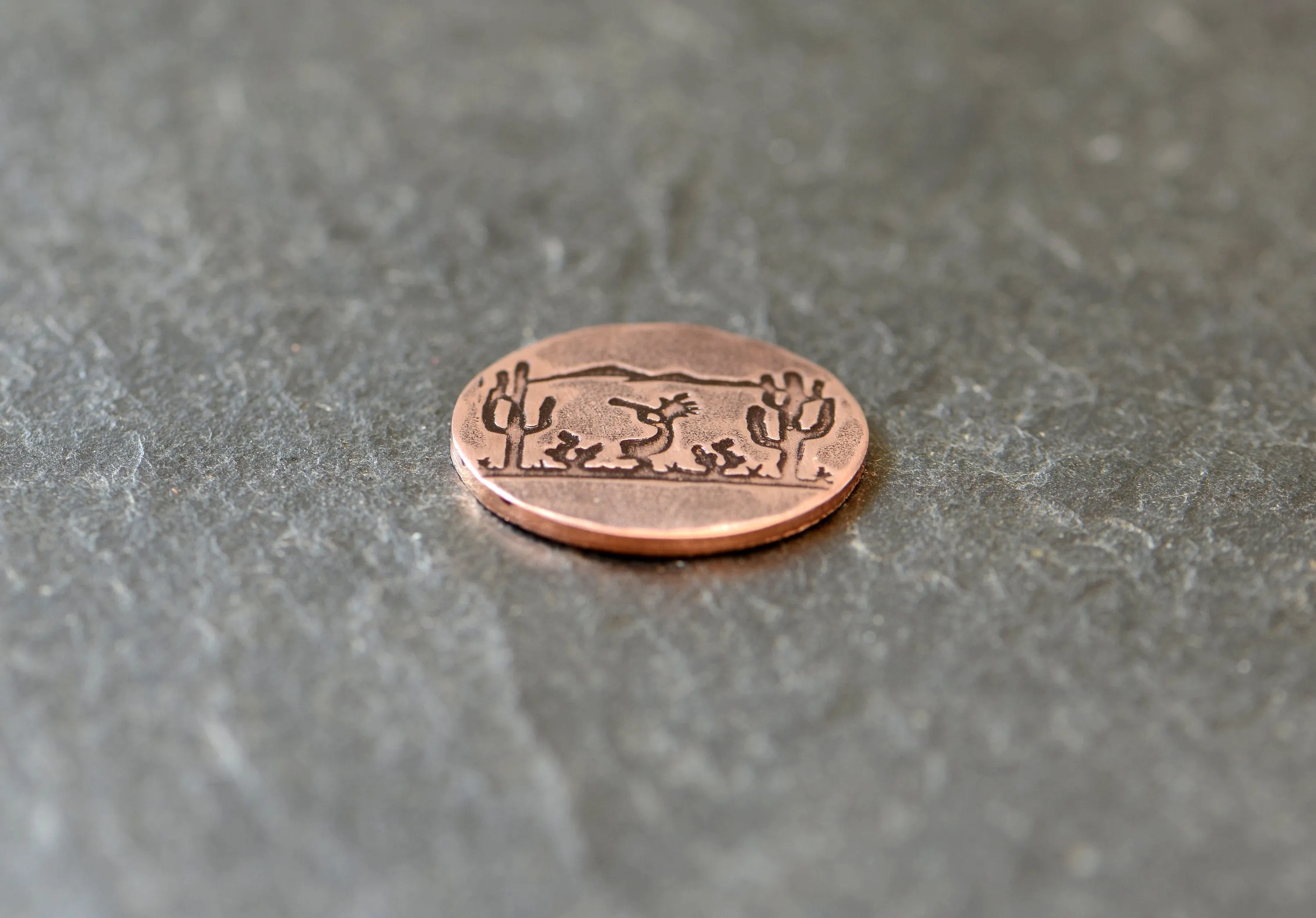 Golf ball marker with saguaro cacti and Kokopelli on copper