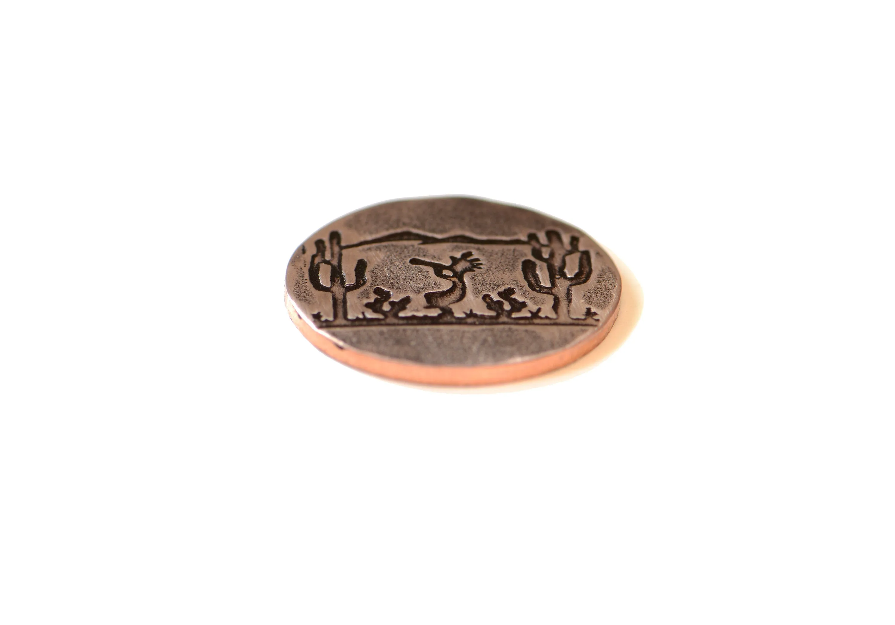 Golf ball marker with saguaro cacti and Kokopelli on copper