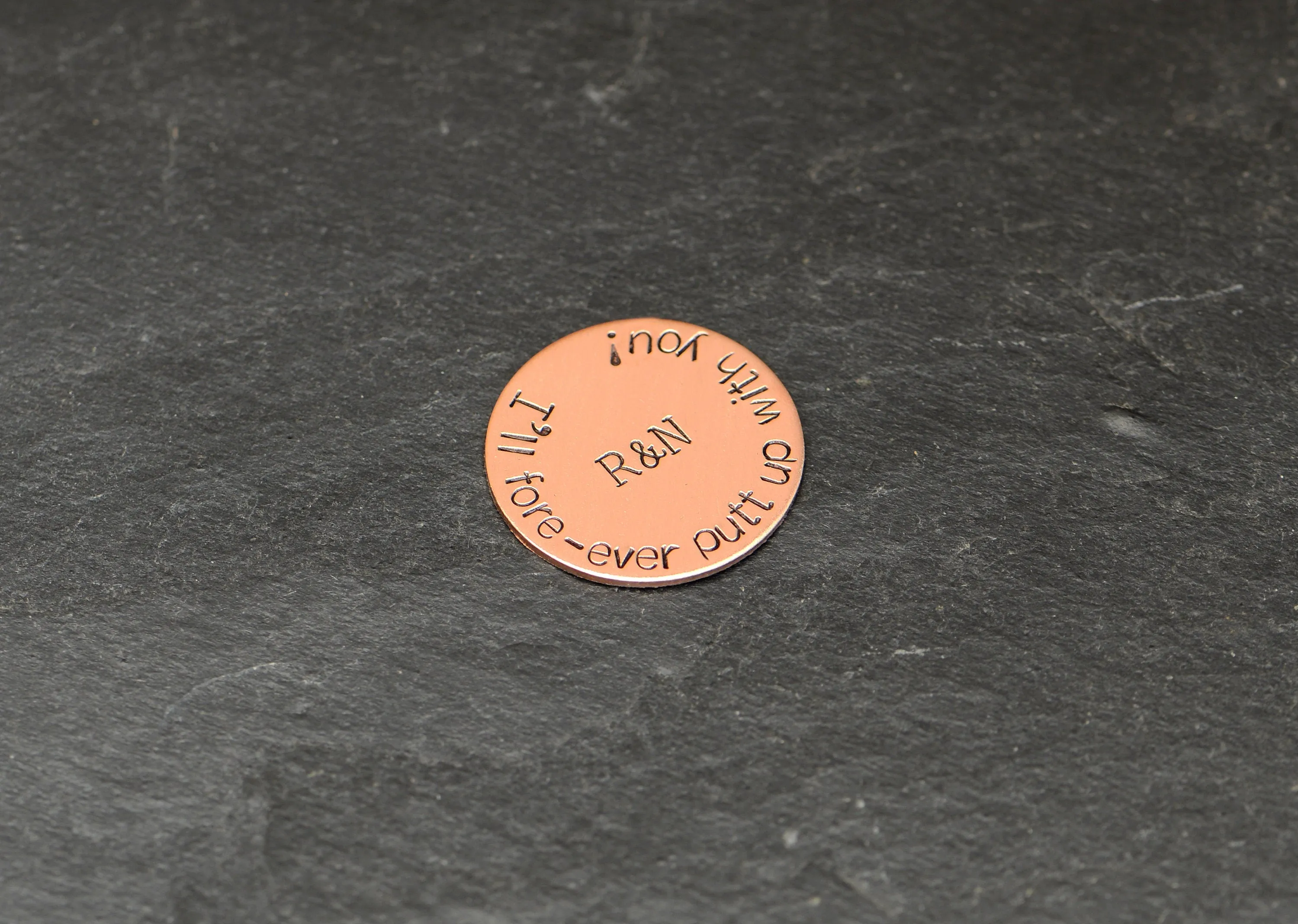 Initials on copper golf ball marker