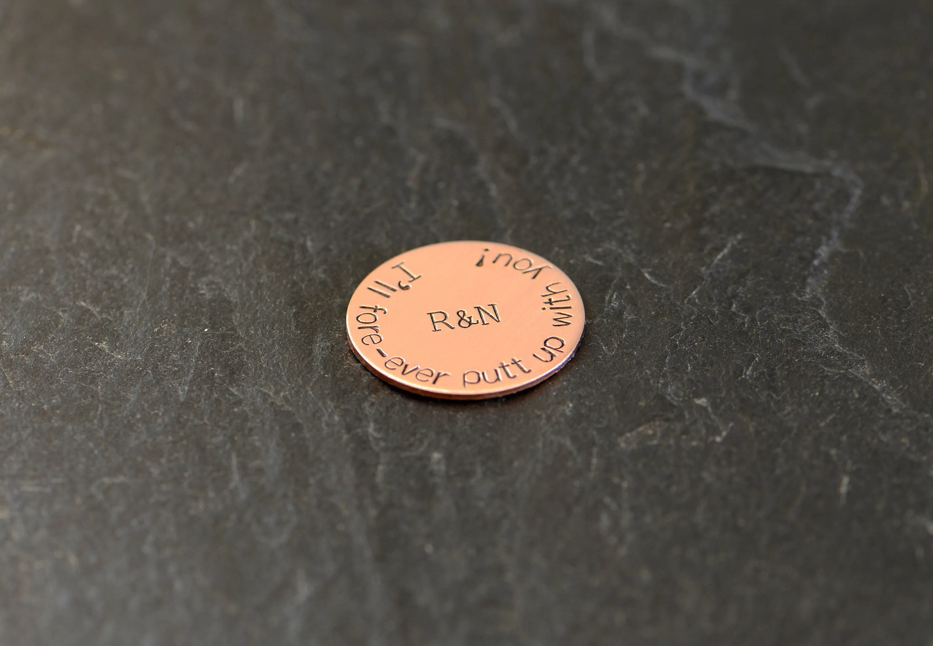 Initials on copper golf ball marker
