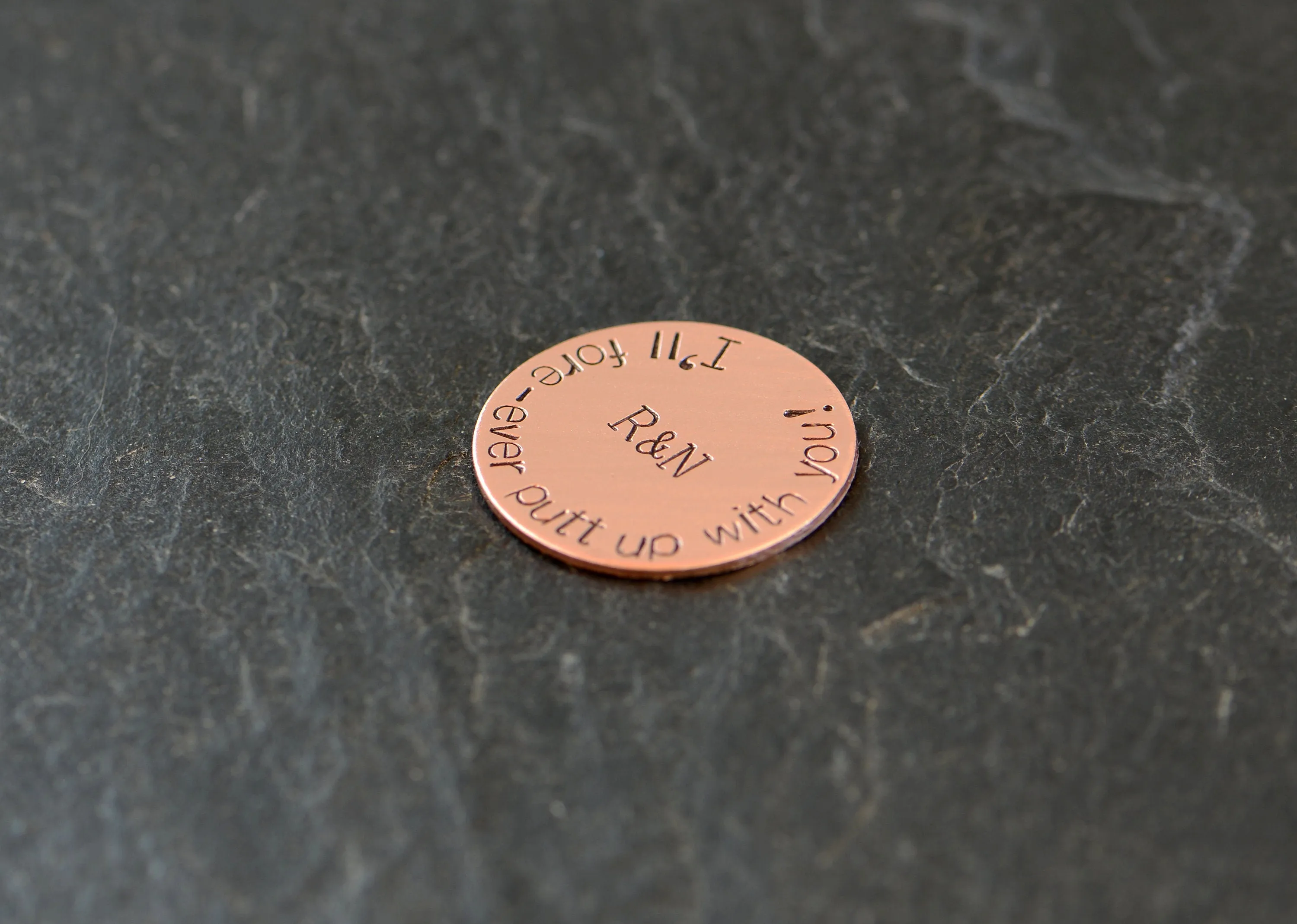 Initials on copper golf ball marker